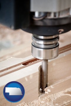 a CNC milling machine cutting wood - with Nebraska icon